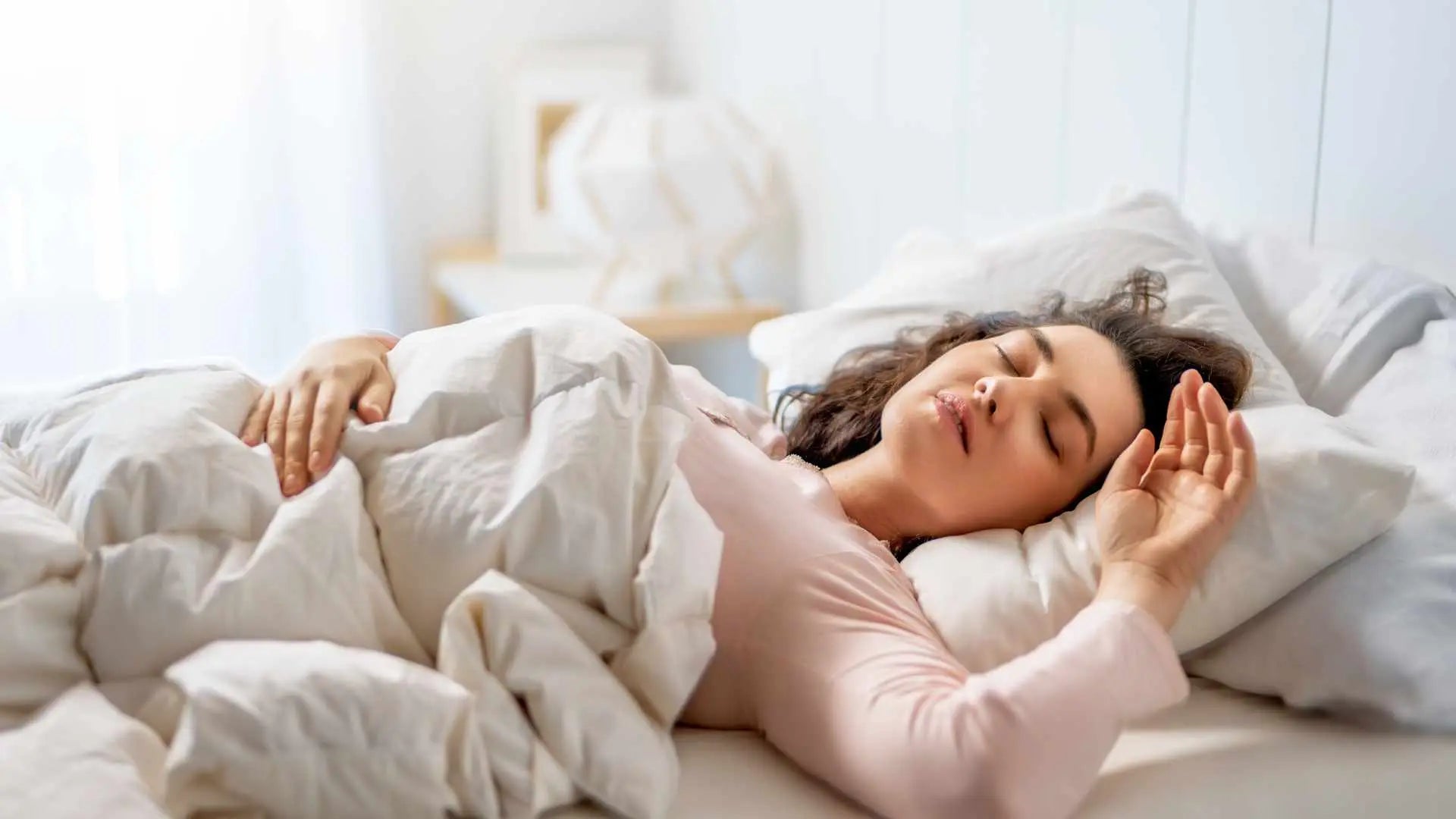 Woman sleeping peacefully in a comfortable bed to support overnight healing and reduced inflammation