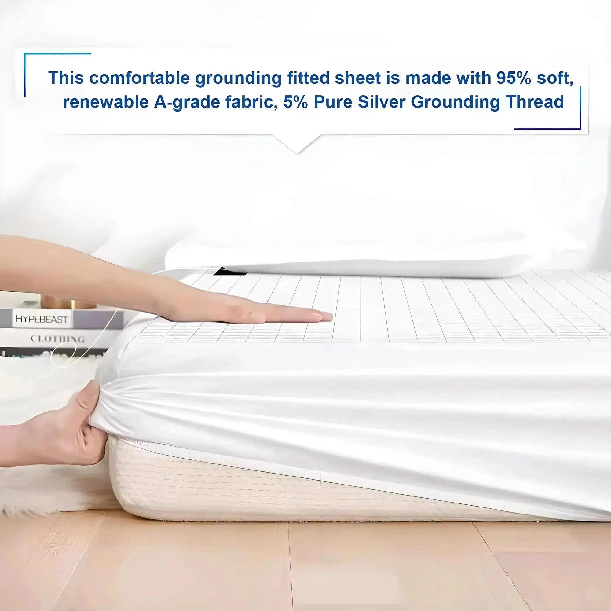 Hands fitting white grounding sheet on bed