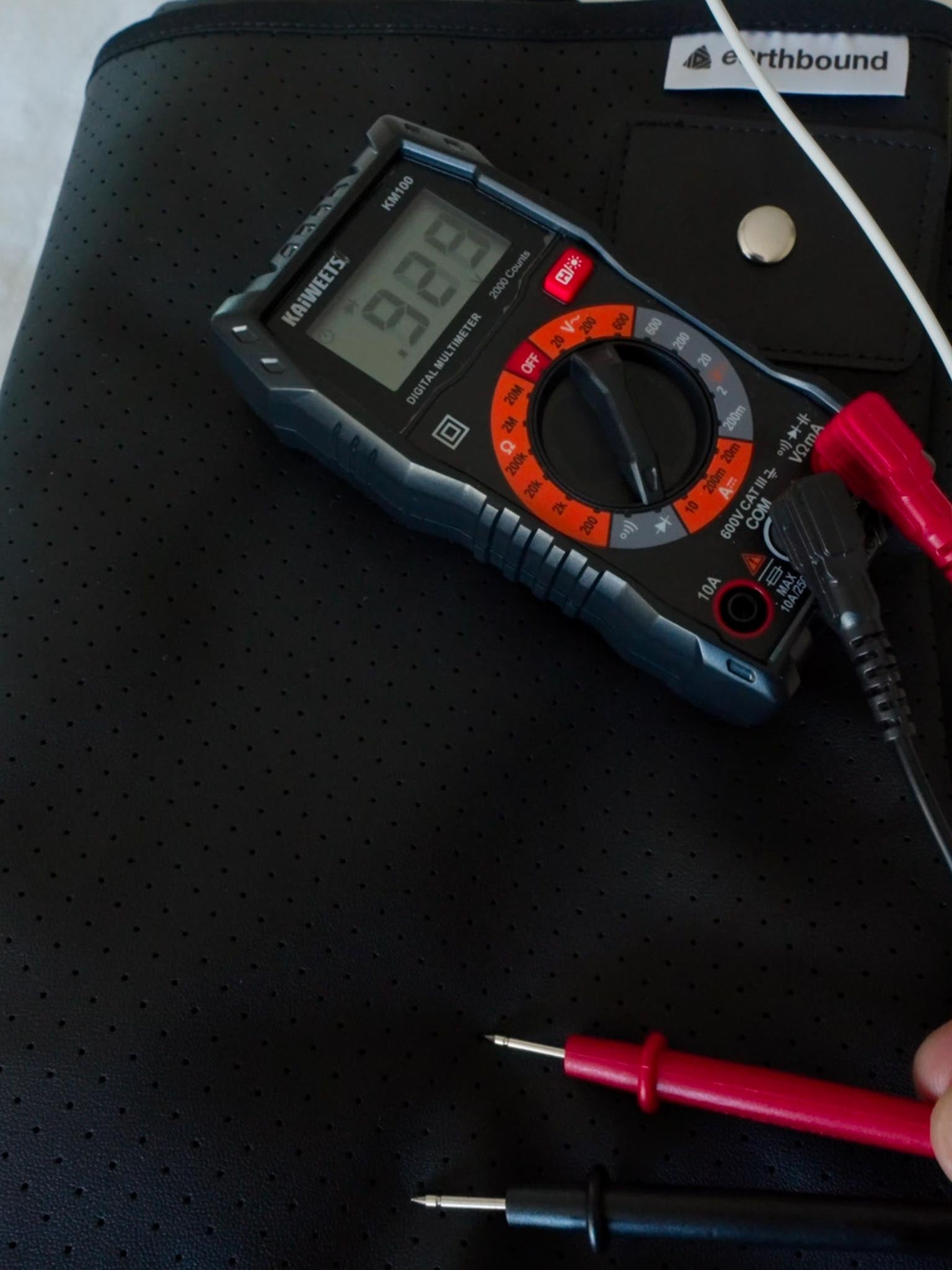 Multimeter measuring grounded Earthbound mat voltage