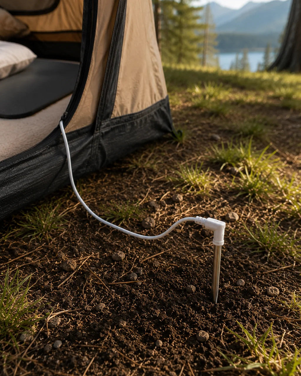 Grounding cord connected to an earthing rod in the soil outside a tent