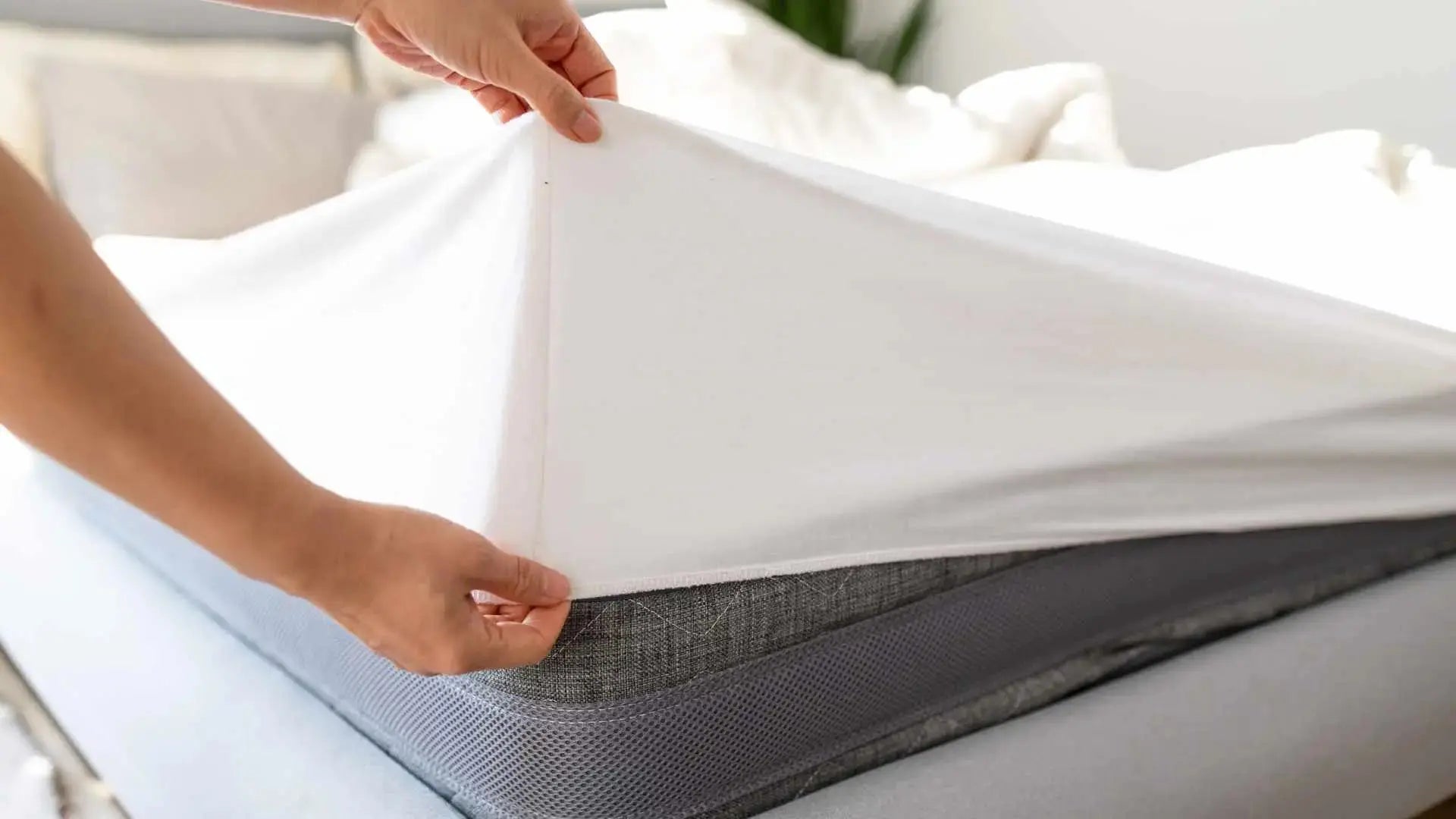 Person placing a grounding mattress pad on a bed to create a conductive sleep surface for earthing during sleep