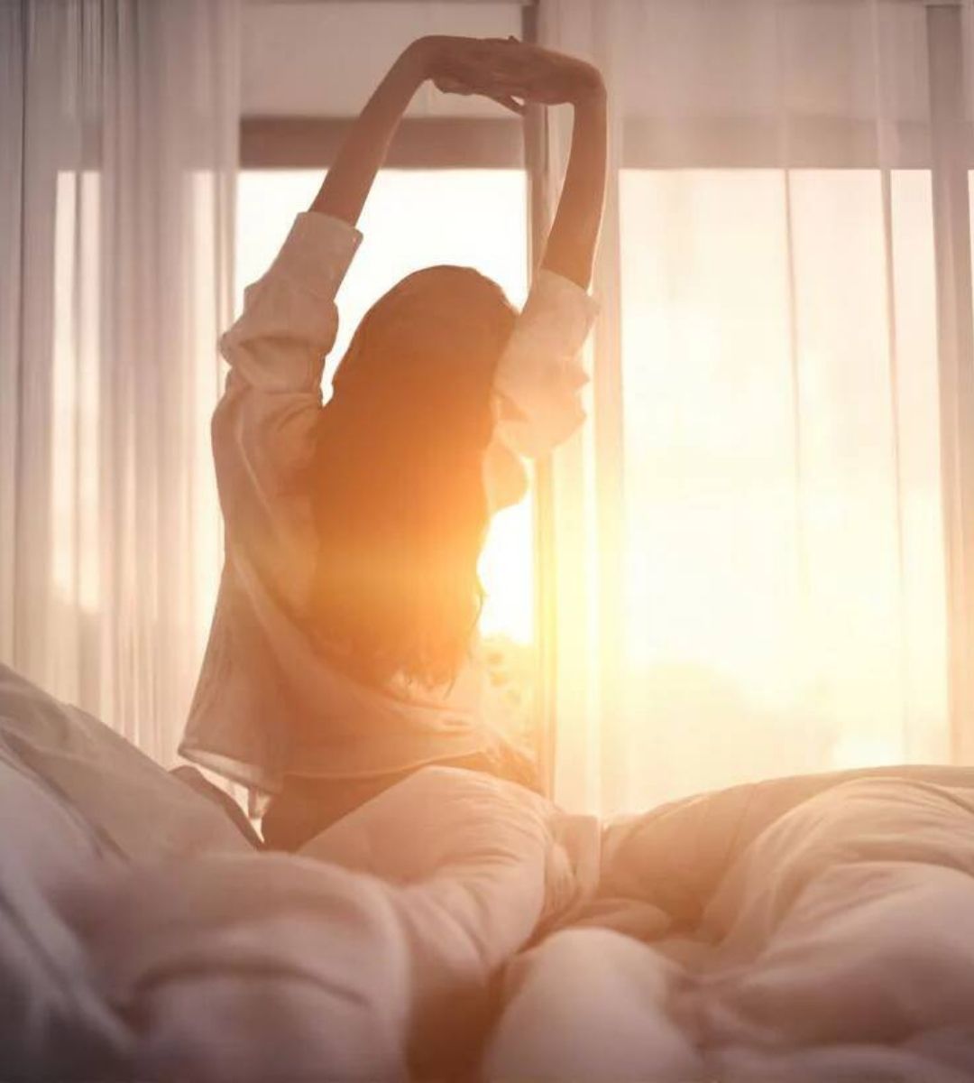 Woman waking rested on an Earthbound grounding mattress pad
