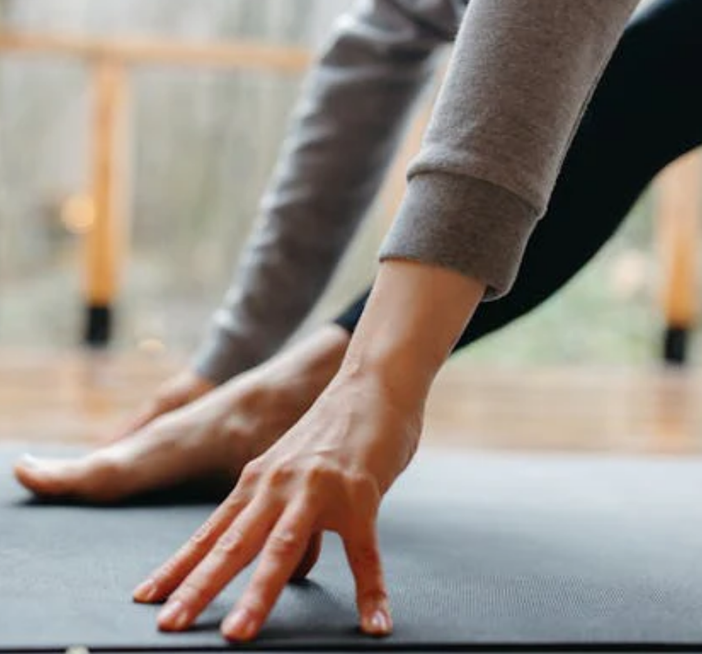 Person stretching on a grounding yoga mat with blurred background